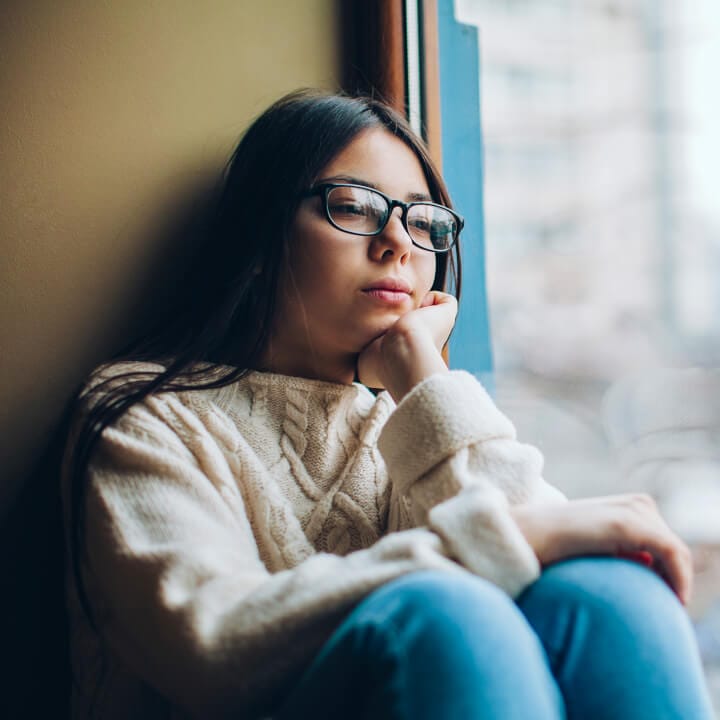 sad girl looking out the window