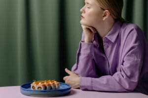 a girl at the table with a plate of sushi